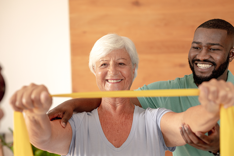 african american male physiotherapist helping senior woman exercise