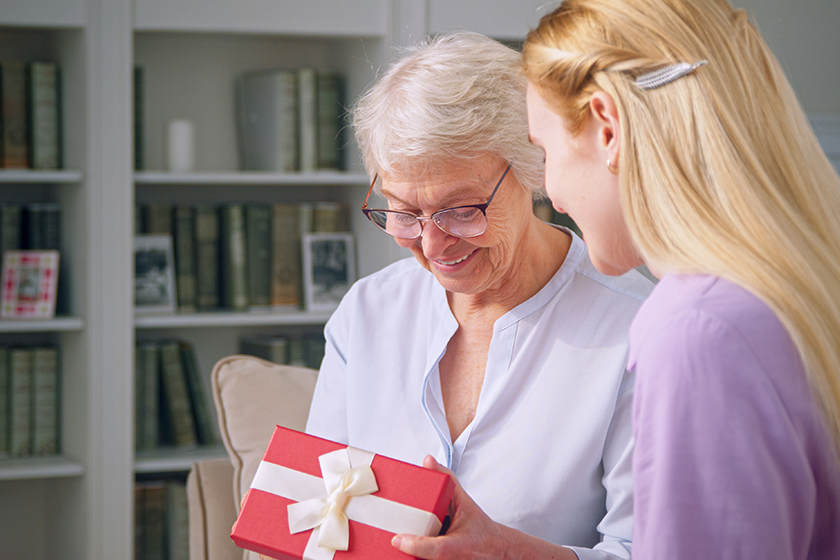 an elderly woman is surprised at the gift of her daughter