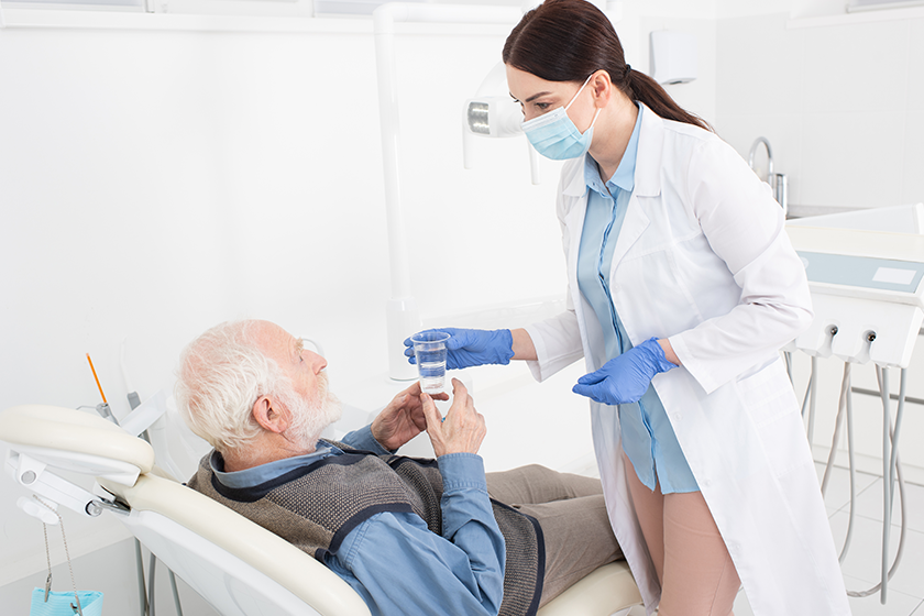 dentist giving glass water senior patient dentist giving glass water senior patient