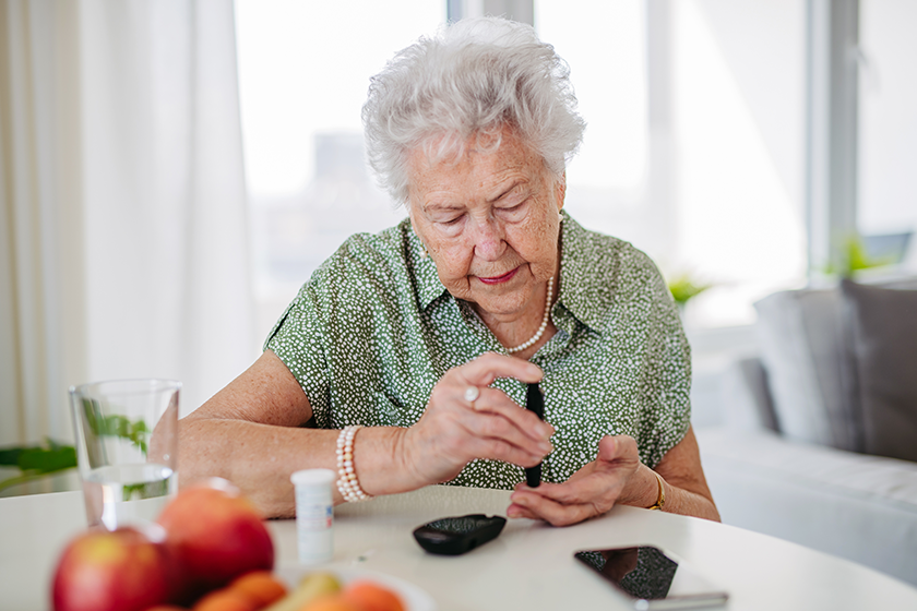 diabetic senior patient checking her blood sugar level diabetic senior patient checking her blood sugar level