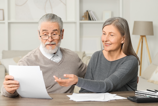elderly couple papers discussing pension plan