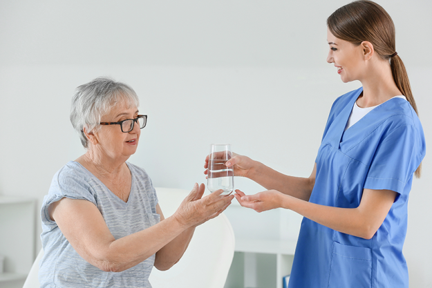 female doctor giving senior woman suffering from parkinson