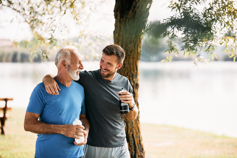 happy athletic man his mature father talking while drinking