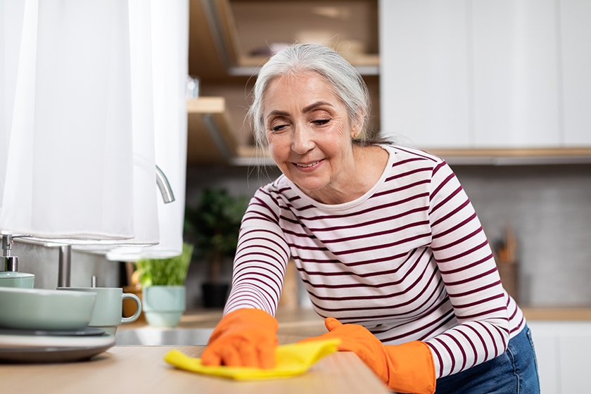 portrait beautiful senior housewife washing table