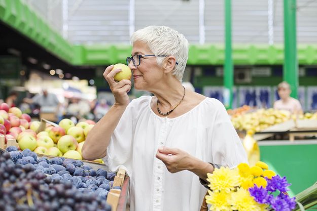 Portrait senior woman buying fruit market