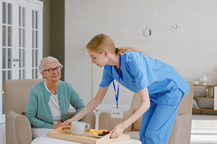 positive young nurse carries tray with breakfast