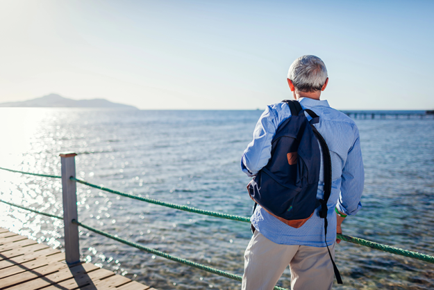 senior man backpack admiring landscape