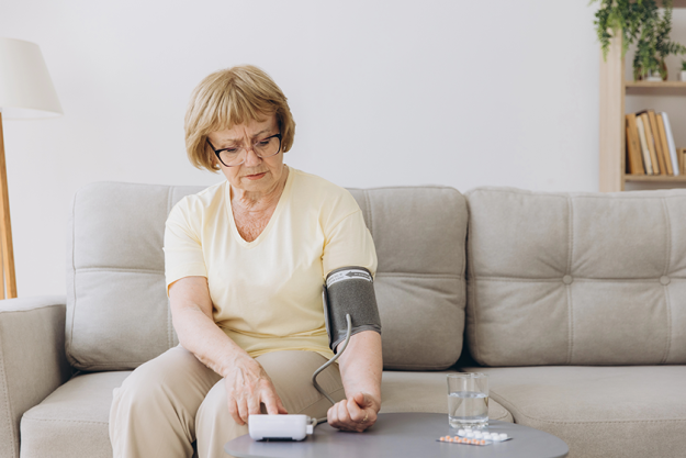 senior woman hypertension measuring blood pressure herself