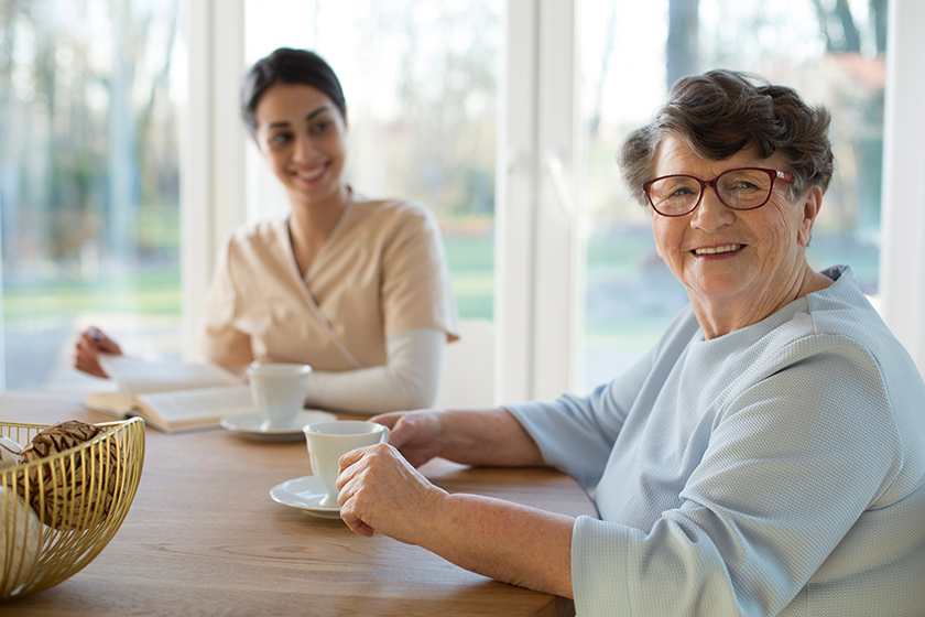 smiling senior woman drinking tea meeting granddaughter smiling senior woman drinking tea meeting granddaughter