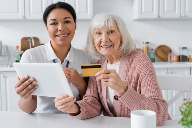 cheerful multiracial social worker holding digital tablet positive senior woman cheerful multiracial social worker holding digital tablet positive senior woman