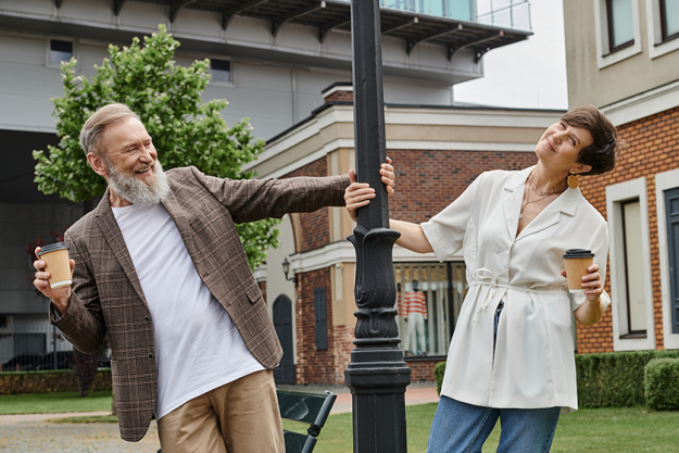 happy senior couple holding coffee standing street lamp happy senior couple holding coffee standing street lamp