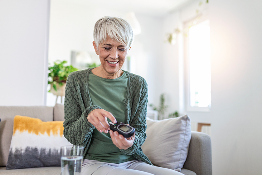 mature woman glucometer checking blood sugar level mature woman glucometer checking blood sugar level