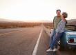 senior couple road trip standing car