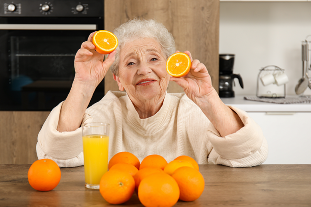senior woman oranges glass juice kitchen