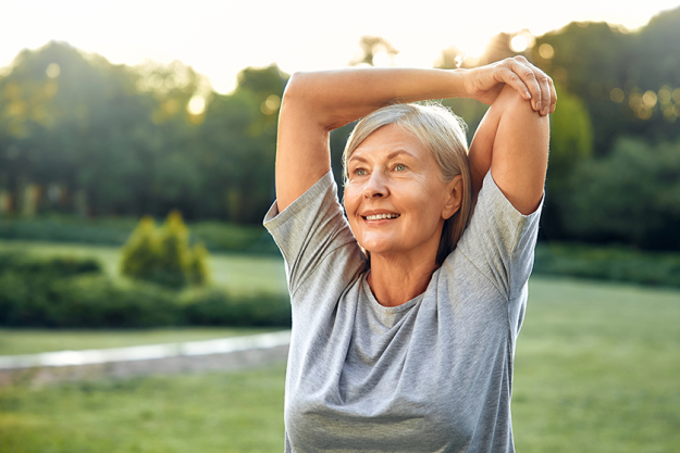 joyful senior woman gracefully stretching her arms joyful senior woman gracefully stretching her arms