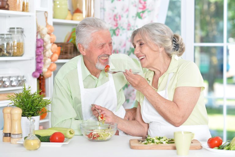 Portrait of a senior couple cooking in kitchen Portrait of a senior couple cooking in kitchen
