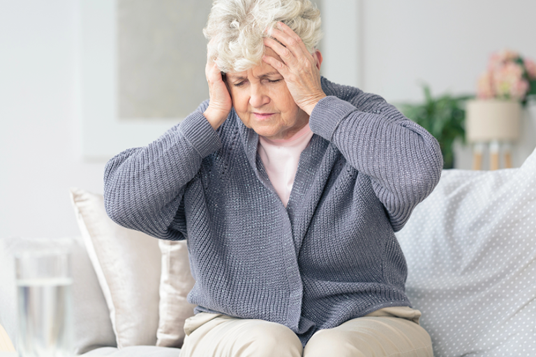elderly woman having migraine