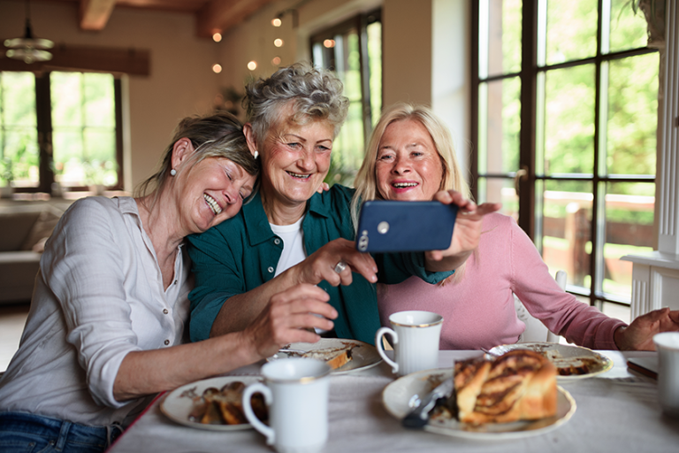 happy senior friends having coffee and cake