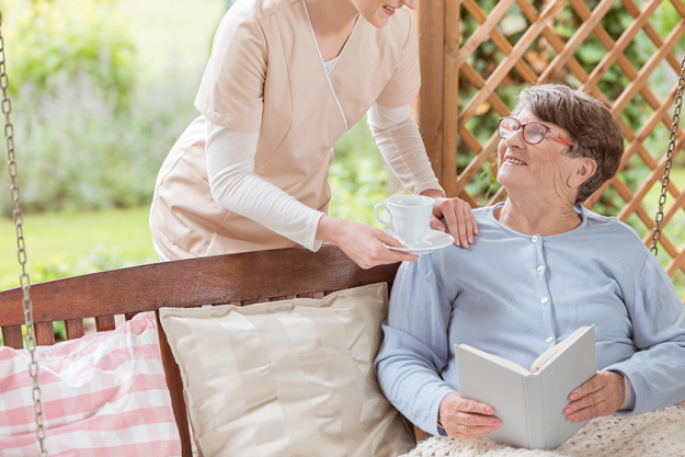 nurse giving tea happy elderly woman