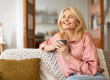 portrait joyful blonde senior woman holding cup