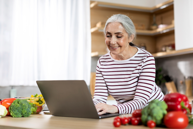 portrait smiling elderly lady using laptop