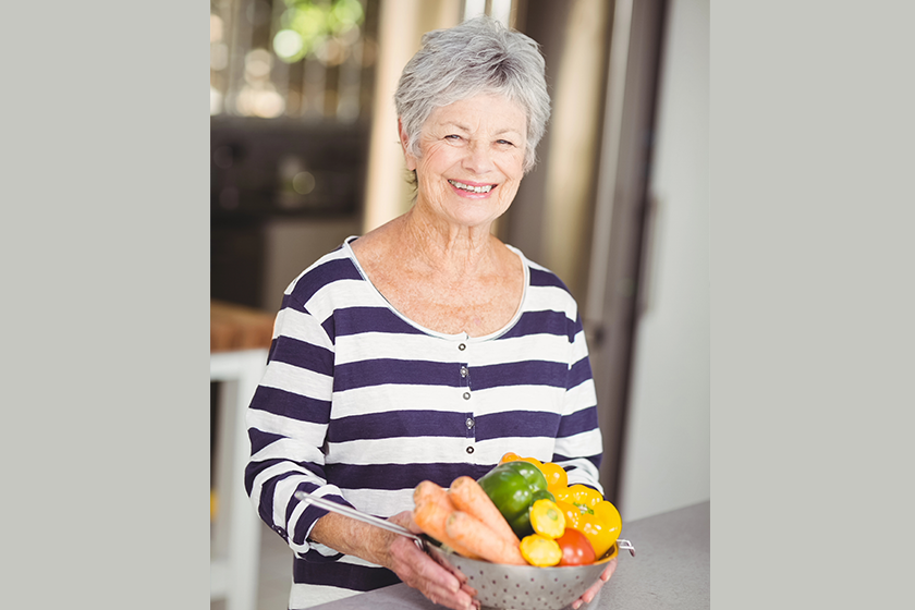 woman holding colander with vegetables woman holding colander with vegetables