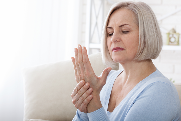 woman massaging her arthritic hand