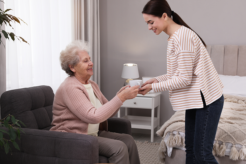 young caregiver giving tea