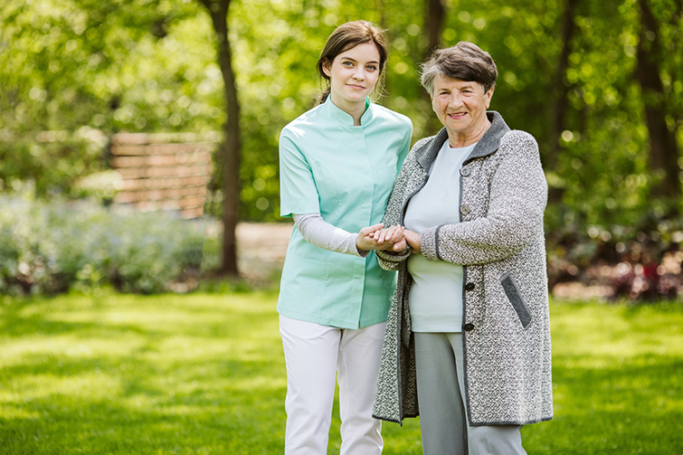 young nurse with elder woman in the garden