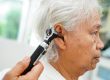 Otolaryngologist or ENT physician doctor examining senior patien