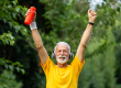 senior man arms raised crossing finish line