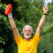 senior man arms raised crossing finish line