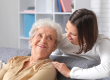 smiling nurse hugging senior woman