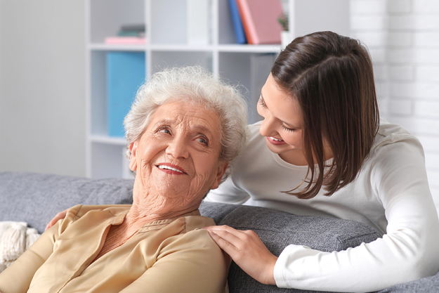smiling nurse hugging senior woman smiling nurse hugging senior woman